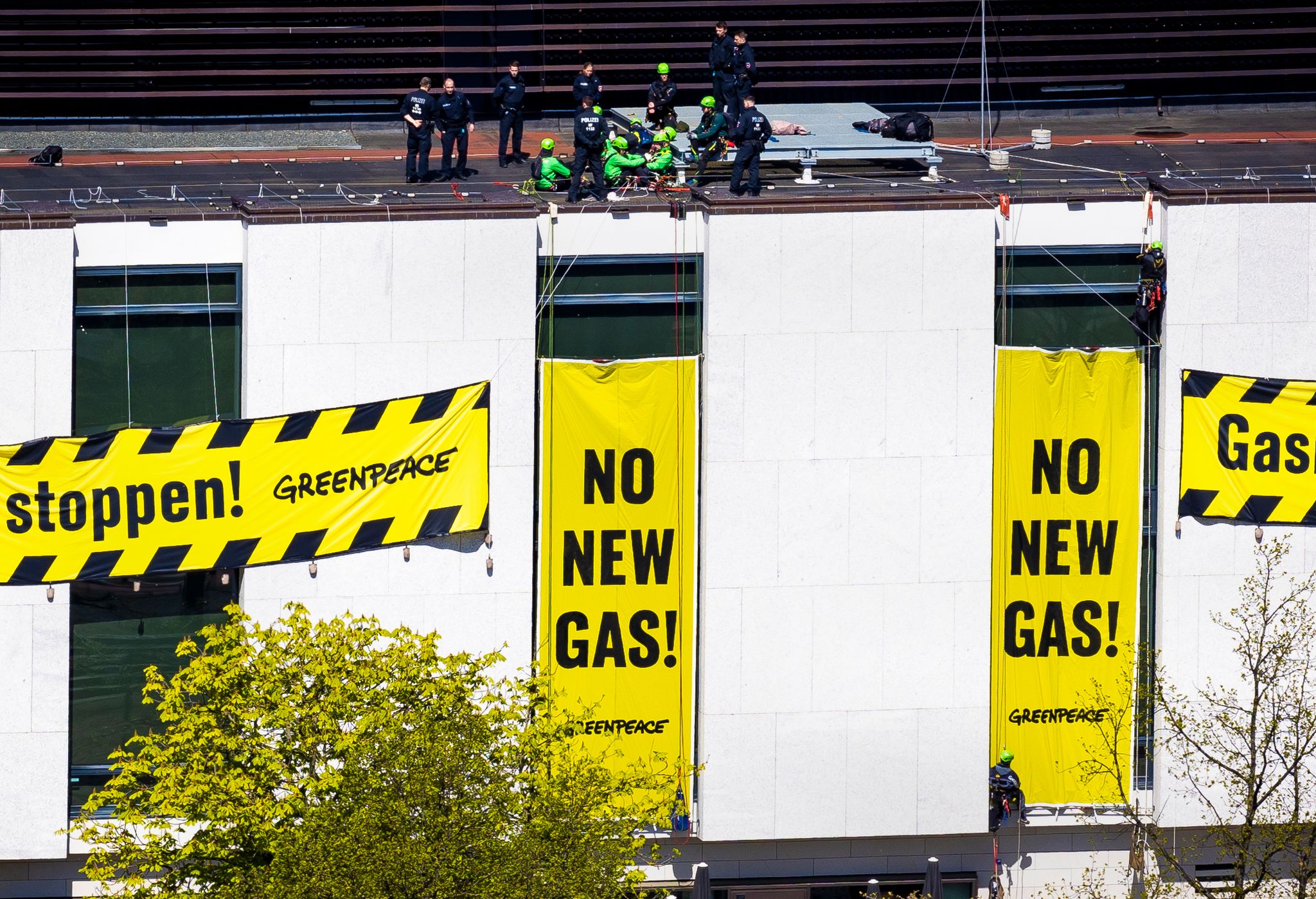 Polizisten stehen auf dem Dach des niedersächsischen Landtags neben Aktivisten von Greenpeace.