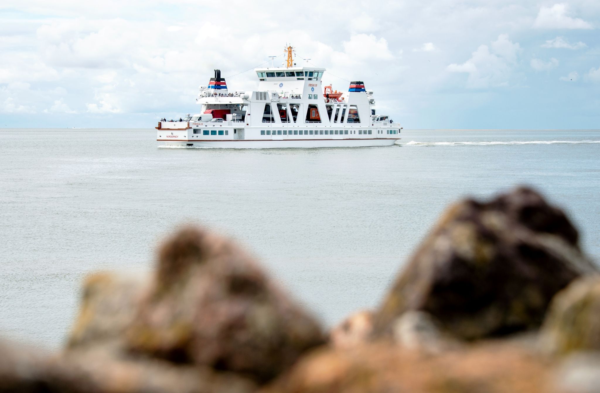 Ein Fährschiff ist im Wattenmeer zwischen Norddeich und Norderney unterwegs.