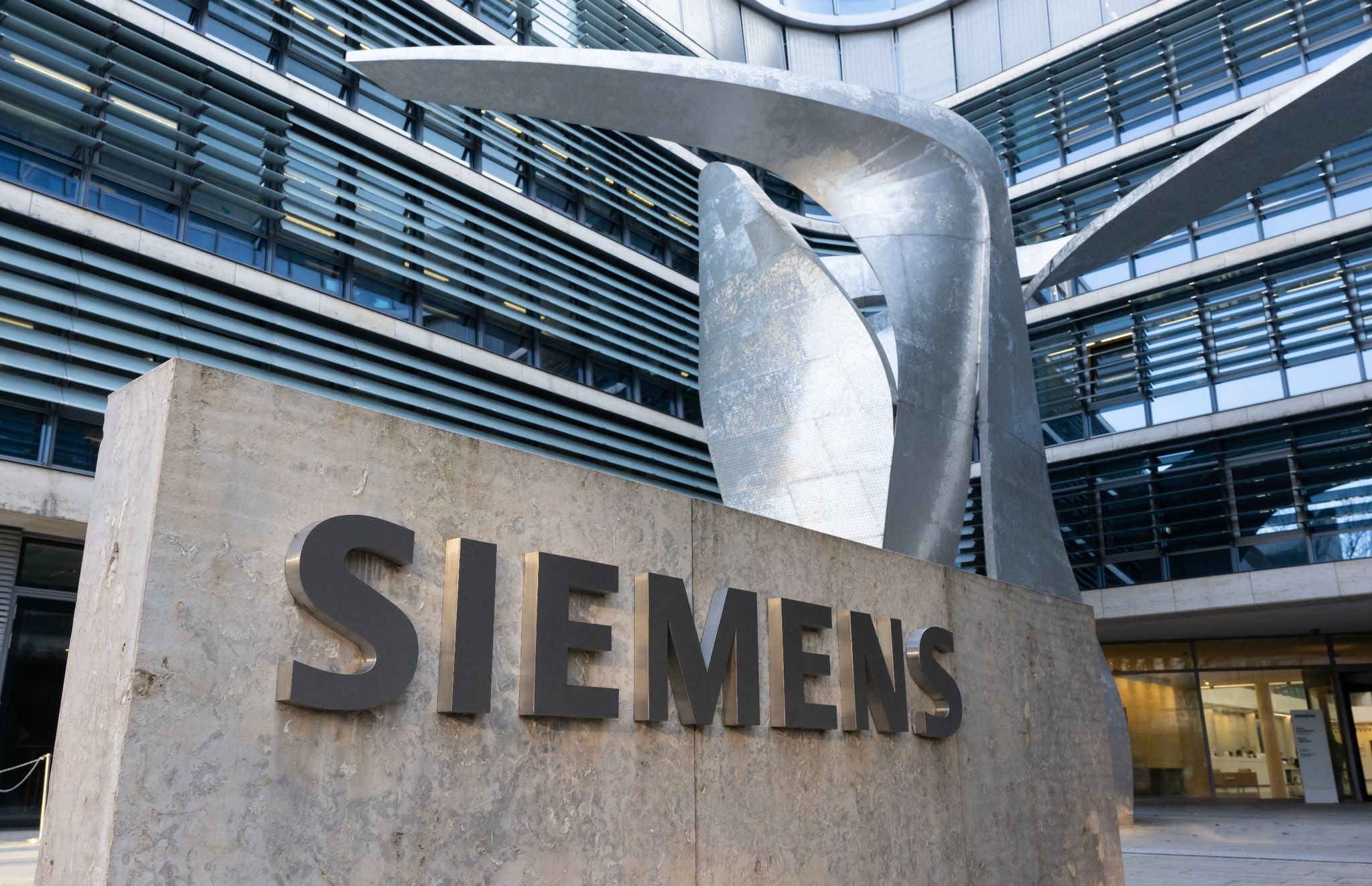 Der Schriftzug "Siemens" ist vor der Firmenzentrale zu sehen.