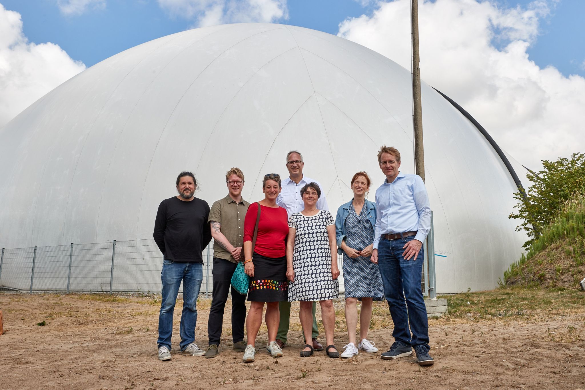 Mitglieder der Landesregierung stehen vor einer Biogasanlage in Tüttendorf.
