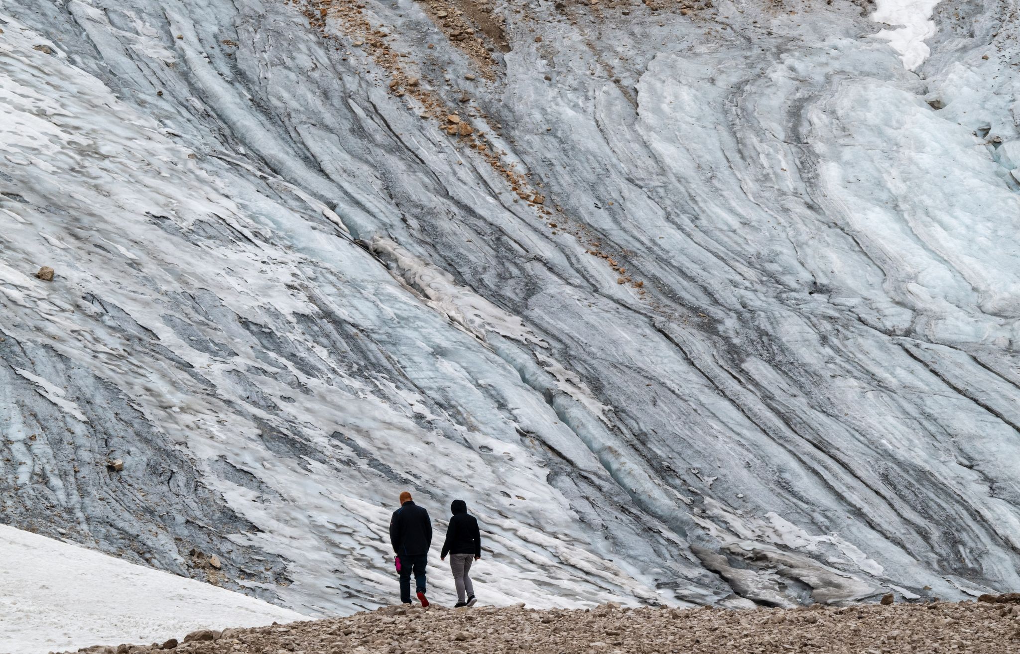 Touristen stehen vor den Resten des Gletschers auf der Zugspitze.