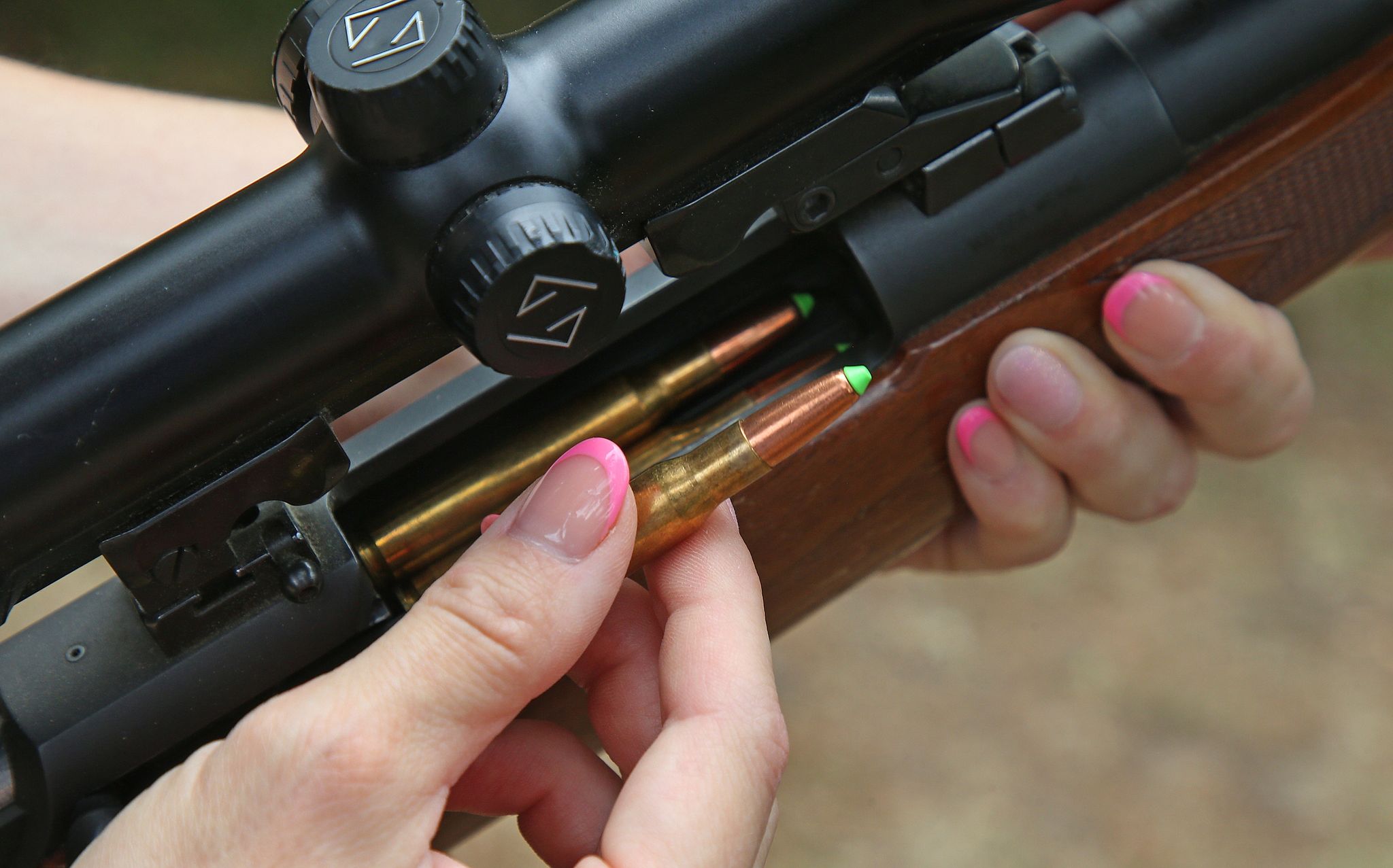 Eine Jägerin lädt ihre Jagdwaffe mit Jagdmunition.