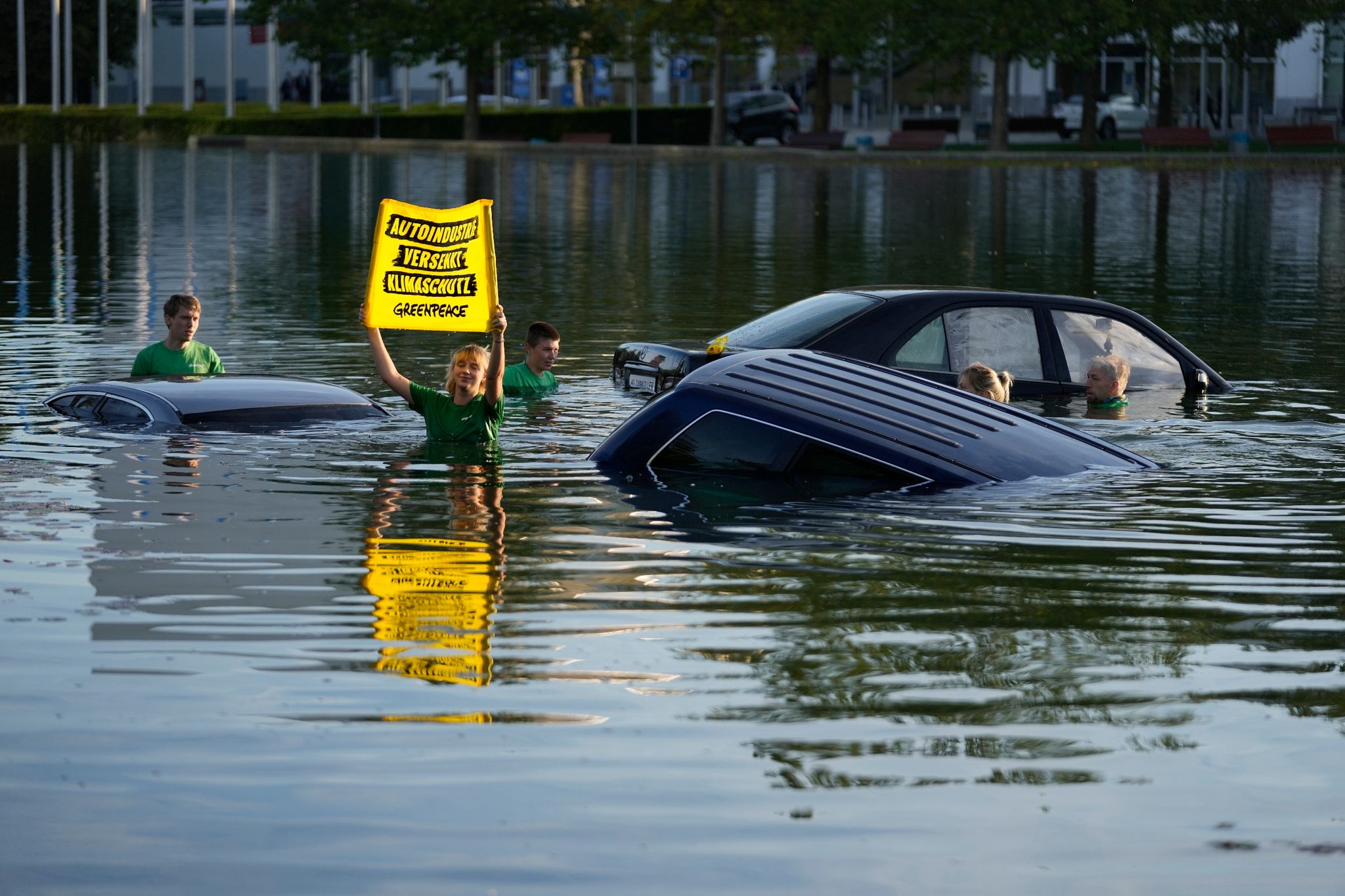 Aktivistinnen und Aktivisten von Greenpeace demonstrieren bei der IAA in München im See vor dem Haupteingang.