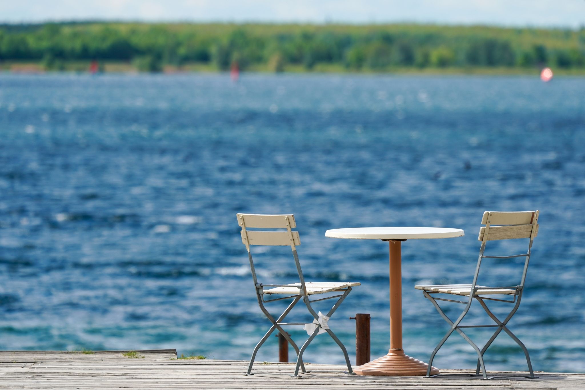 Ein unbesetzter Tisch steht auf einem Freisitz am Cospudener See bei Leipzig.