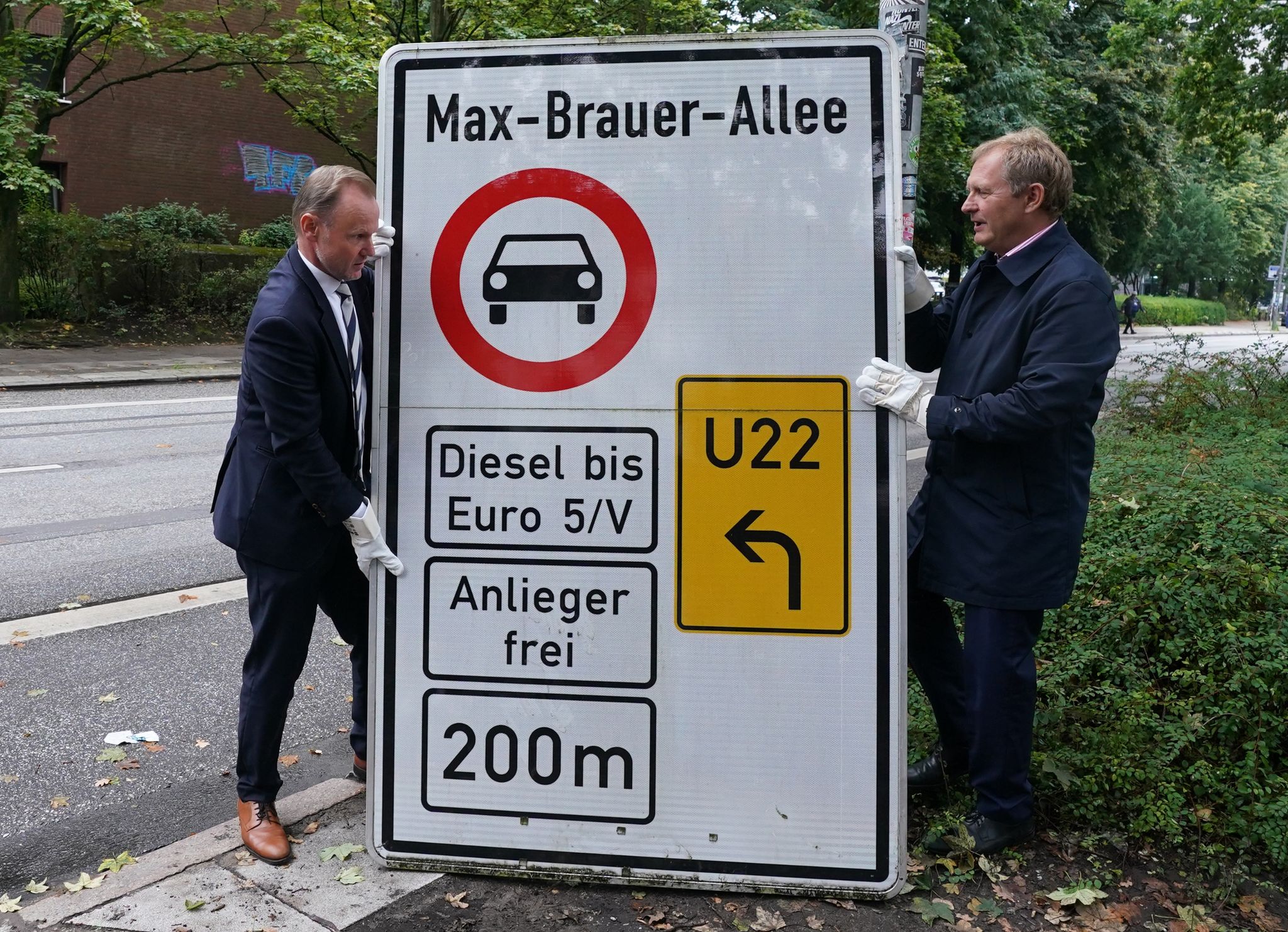 Innensenator Andy Grote (l) und Umweltsenator Jens Kerstan demontieren ein Schild.