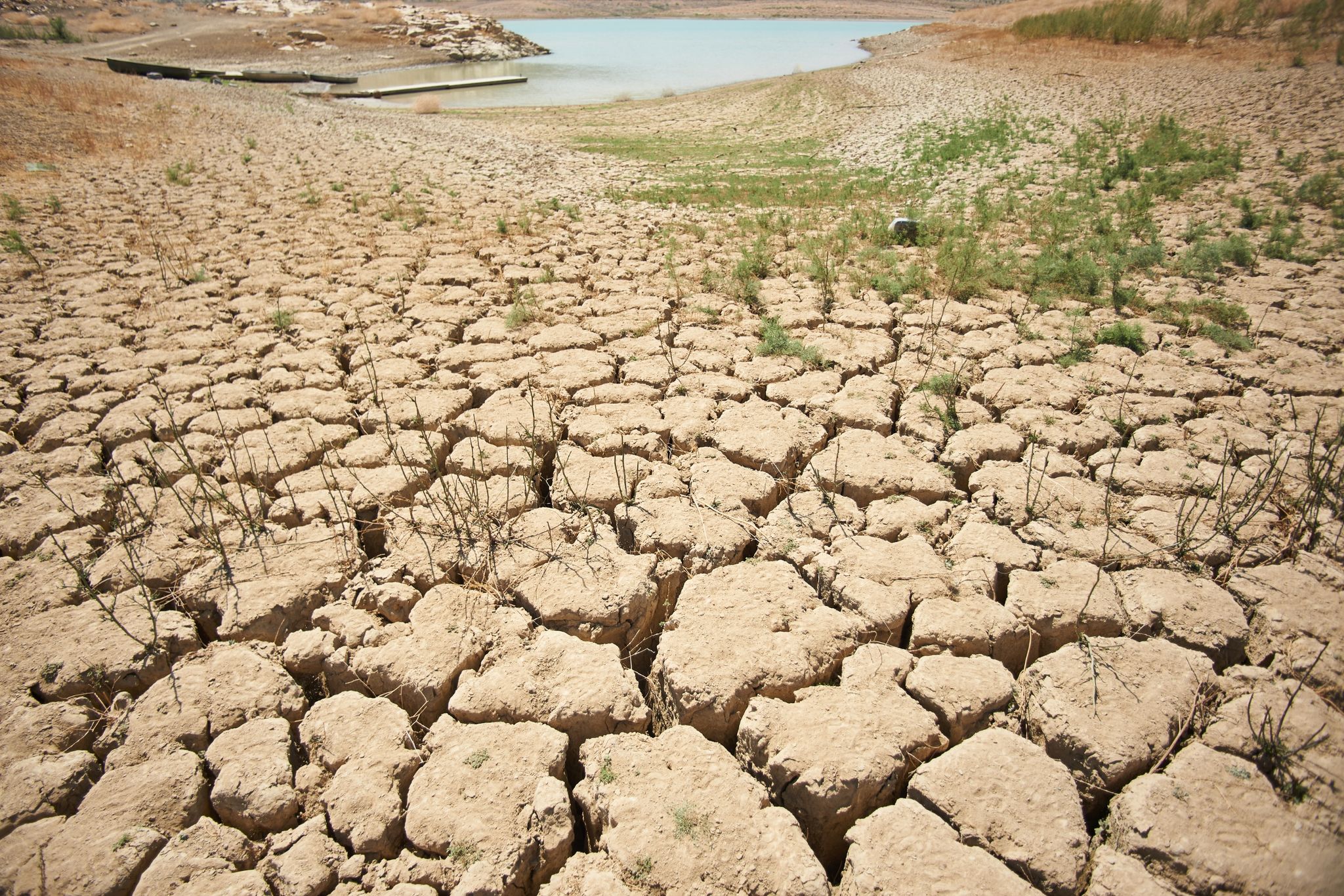 Ein Symptom des schlechten Zustands der Erde: von der Trockenheit zerklüftete und aufgerissene Erde an den Ufern des Viñuela-Stausees in Spanien.