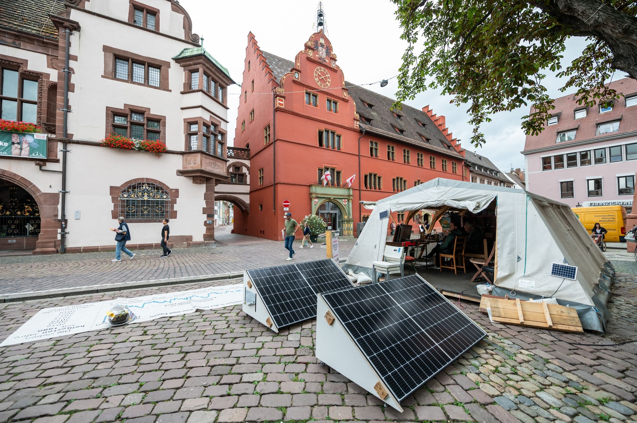 Solarzellen und ein Zelt des Klimacamps stehen vor dem Neuen Rathaus.