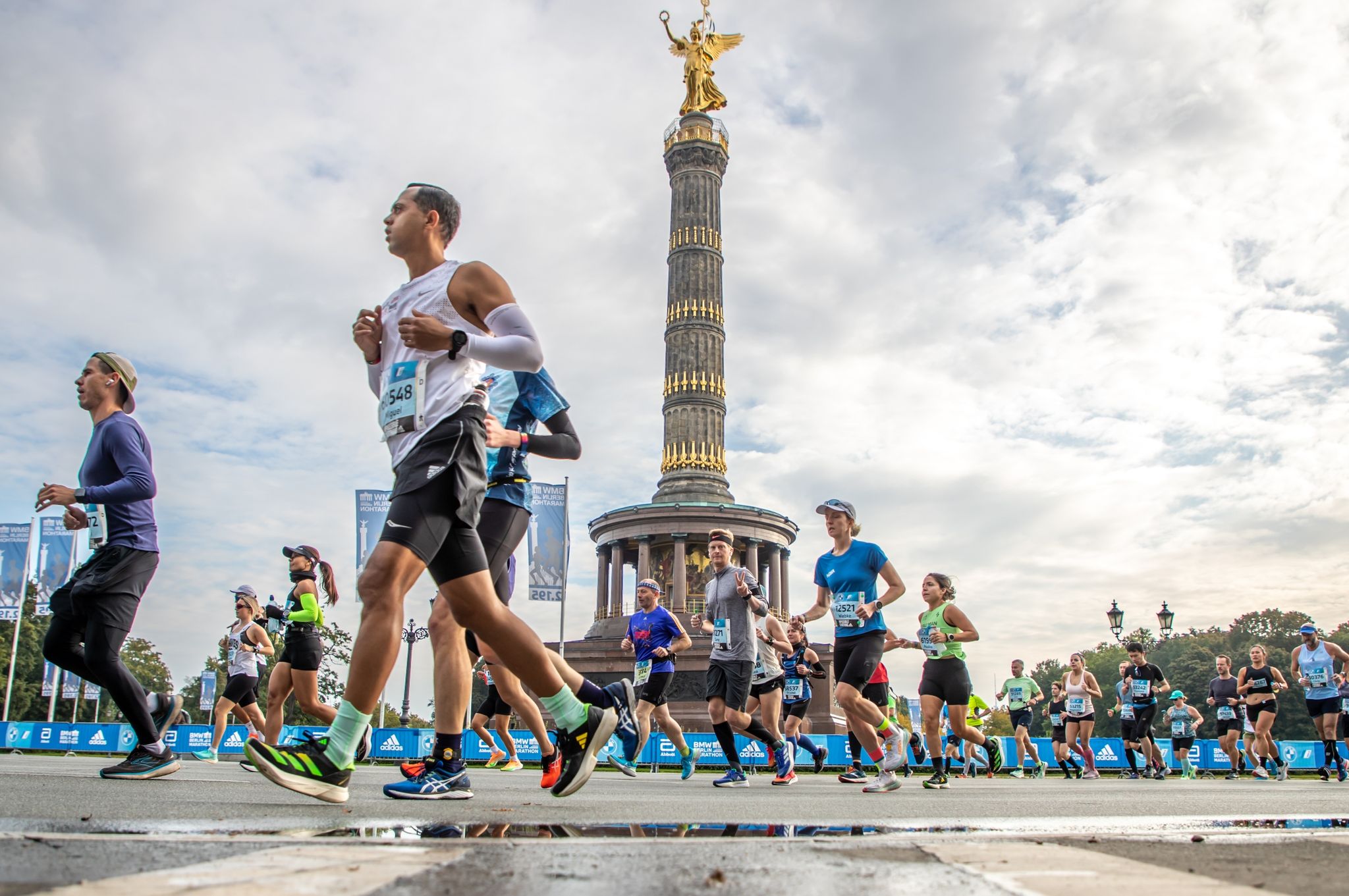 Die Läufer der ersten Welle des BMW Berlin Marathon passieren auf der Straße des 17. Juni die Siegessäule.