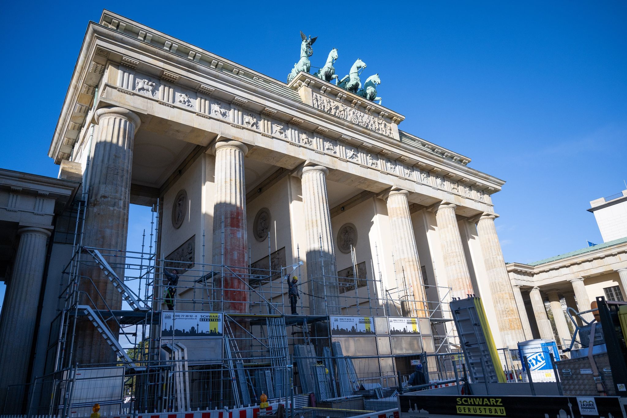 Auf einer Seite des Brandenburger Tors wird ein Baugerüst aufgebaut, um die Folgen der Farbattacke zu beseitigen.