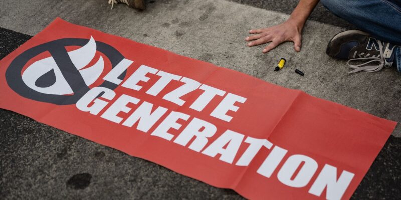 Ein Aktivist der Gruppe «Letzte Generation» blockiert eine Kreuzung.